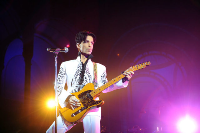 Prince performs onstage with guitar