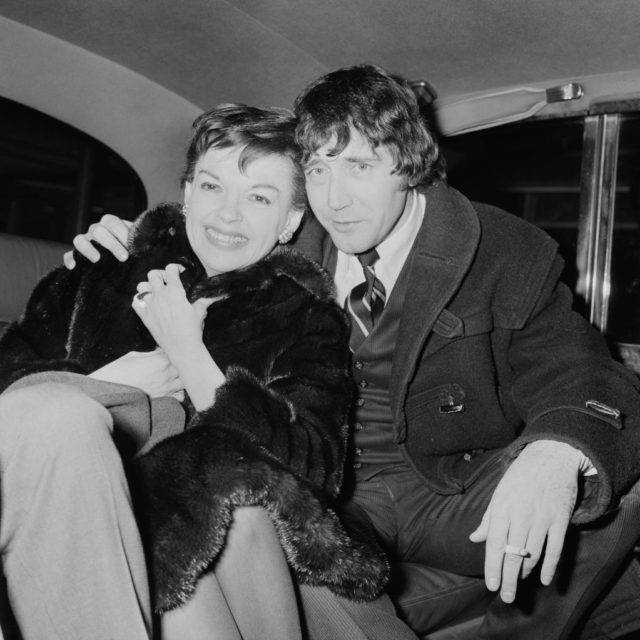 Judy Garland and Mickey Deans sitting in the backseat of a car