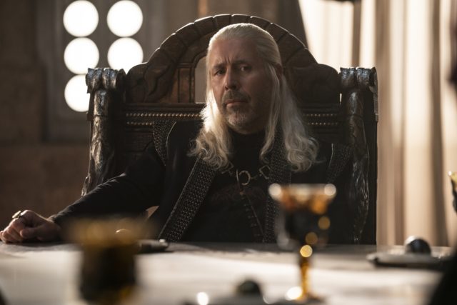 Paddy Considine plays Viserys Targaryen, sitting at a table