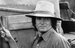 Black and white photo of Michael Landon from 'Little House on the Prairie' wearing a hat and collared shirt.