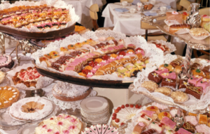 Colored photo of a table with lots of desserts on it.