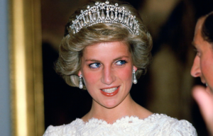 Colored photo of Princess Diana wearing a tiara smiling while looking off to the side.