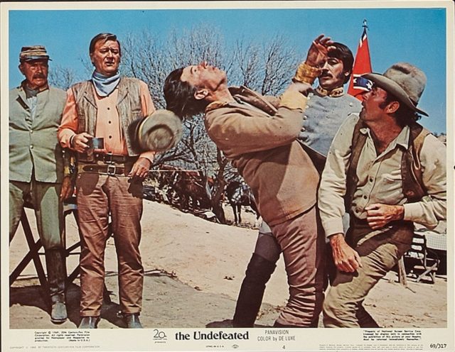 Lobby card from The Undefeated shows a man getting punched