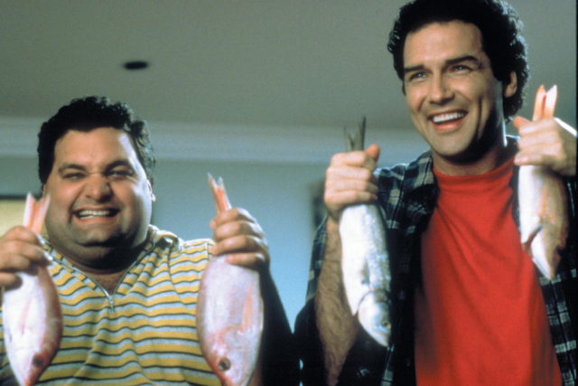 Artie Lange and Norm Macdonald in 'Dirty Work' holding up fish in each of their hands while they smile.