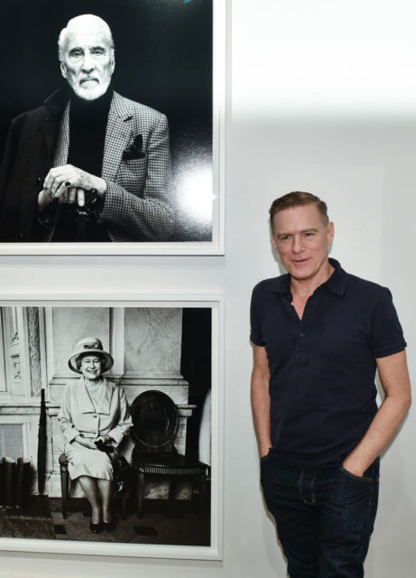 Bryan Adams poses next to his portrait of the Queen at an exhibit