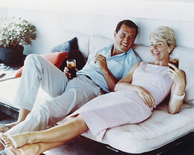 Rock Hudson and Doris Day on a couch holding drinks