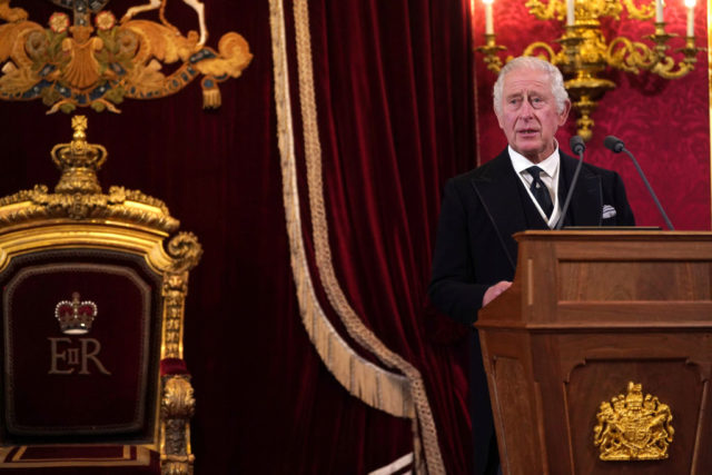 King Charles III standing at a podium giving his proclamation.