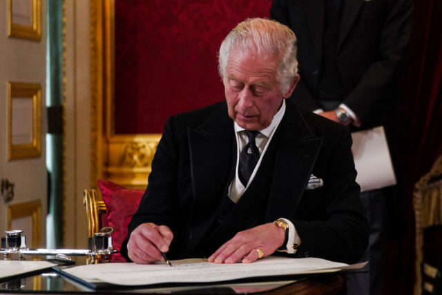 King Charles III signs a contract