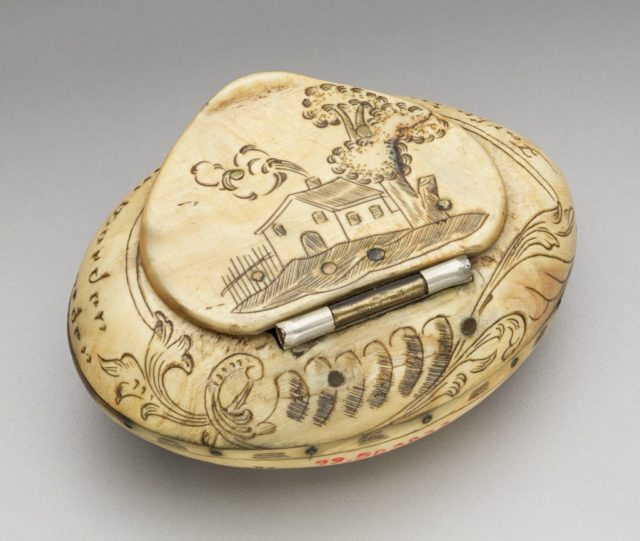 A snuff box carved out of bone with intricate details