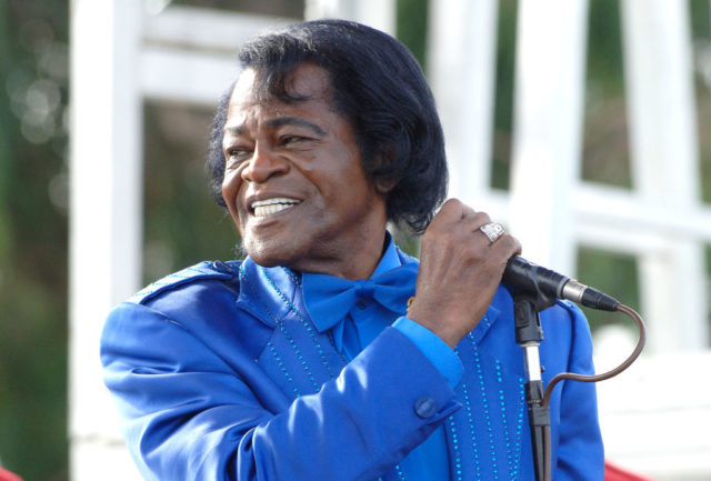 James Brown holds a microphone