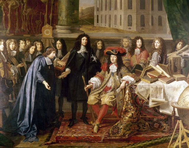 King Louis XIV in a red outfit fitting while a group of scholars look on at him.