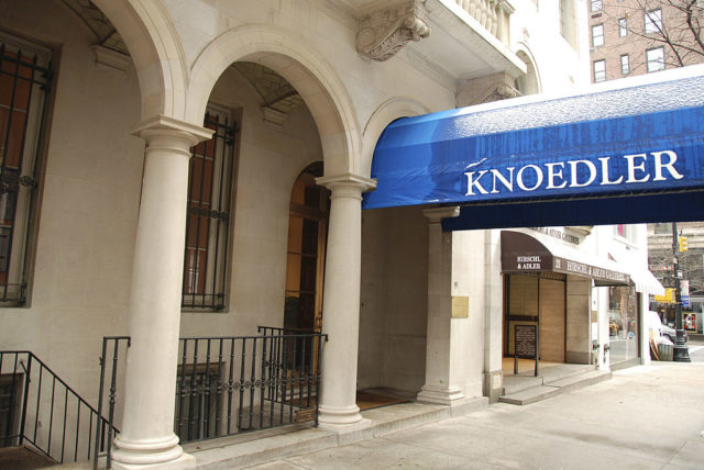 Knoedler Gallery in New York with pillars and a large blue awning at the front of the building.