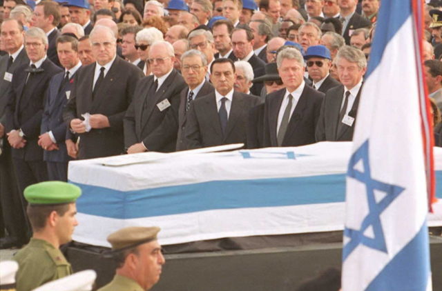 Large group of political figures gathered in the background, with the casket of Yitzhak Rabin in the forground.