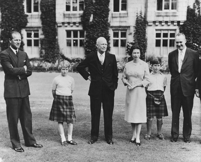 Black and white photo of President Eisenhower alongside King Charles III and other members of the royal family.