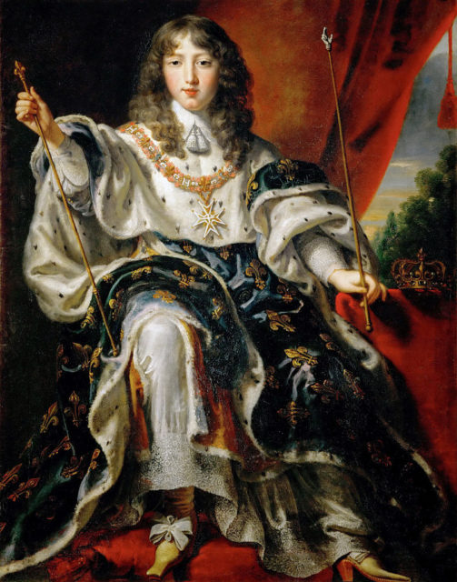 Young King Louis XIV sitting down wearing robes and holding two scepters.