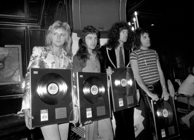 Queen holding their awards from the British Phonographic Institute