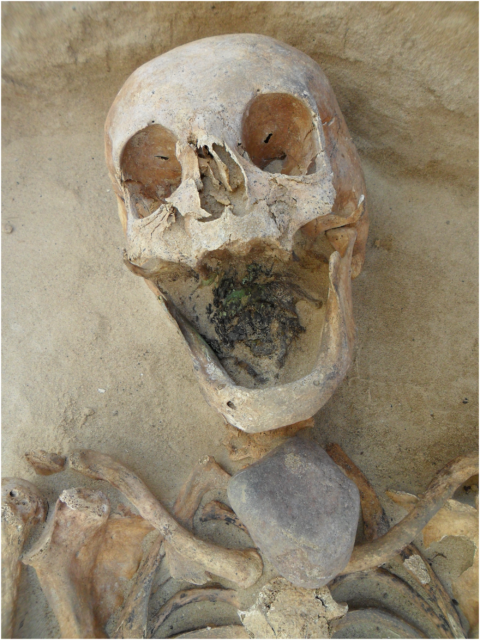 Skeleton with a stone placed over the throat bones.