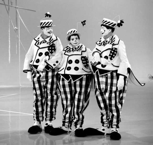 Judy Garland, Donald O'Connor, and Jerry Van Dyke dressed in clown costumes with make up.