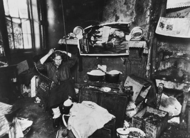 A woman in a cluttered and dirty tenement apartment 