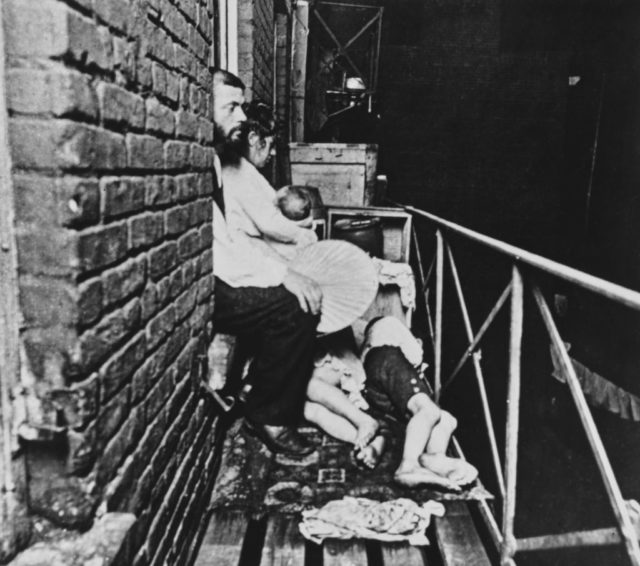 A family with young children asleep on a tenements fire escape