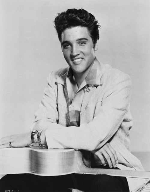 Portrait of Elvis Presley with a guitar on his lap