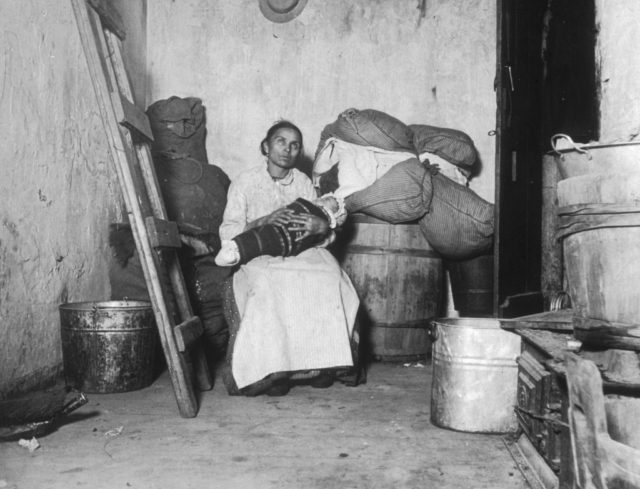 A woman with her baby in a tenement room