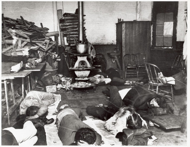 Men sleeping on the floor of a run down room