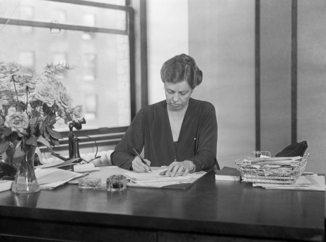 Eleanor Roosevelt looking down, writing something at her desk