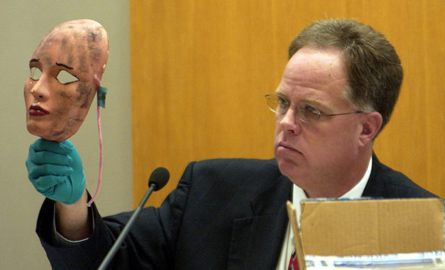 A detective holds up a dirty women's mask used by Rader in one if his crimes