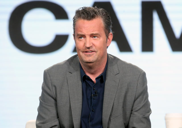 Headshot of Matthew Perry in a grey blazer