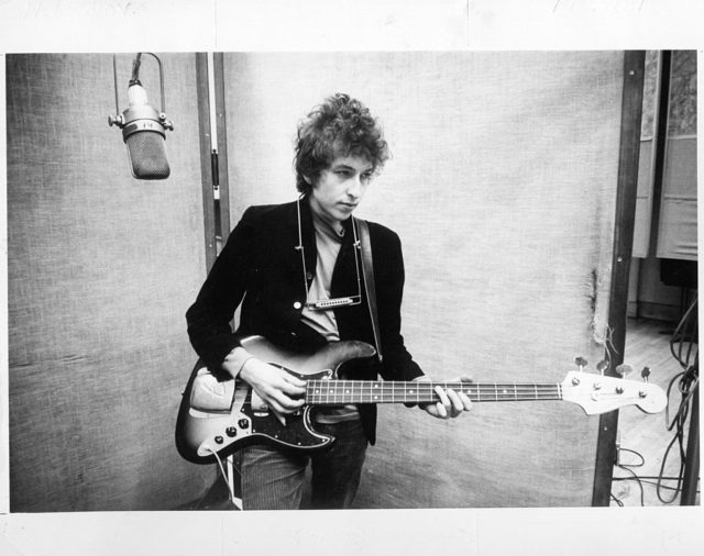 Bob Dylan plays a bass guitar while in the recording studio