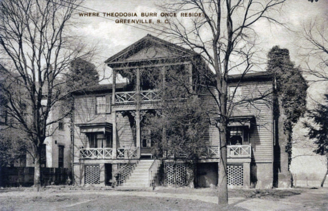 A home with a big porch and trees in the front