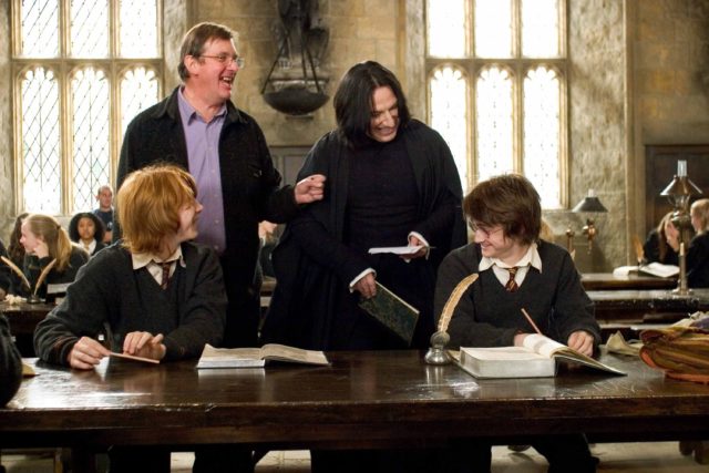 Alan Rickman dressed as Snape alongside Rupert Grint, Daniel Radcliffe, and Mike Newell. 