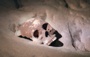 Mayan skull sitting in sand.