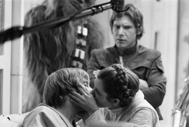 Photo of Mark Hamill and Carrie Fisher kissing while filming Star Wars: The Empire Strikes Back