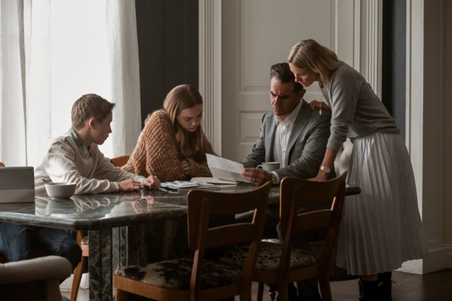 A still of the family reading a letter in 'The Watcher'