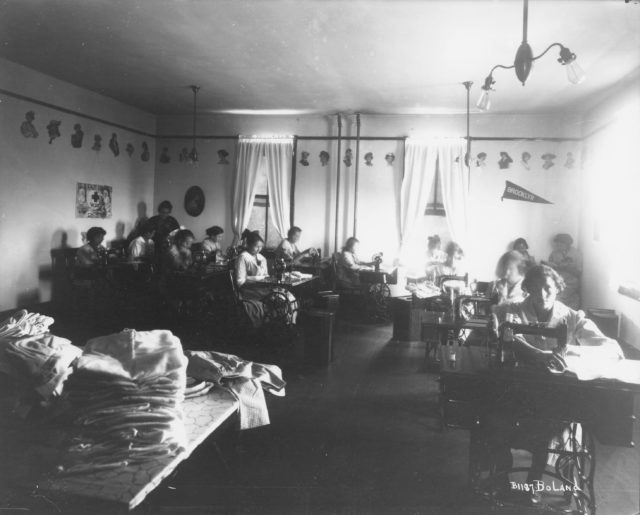 Girls at sewing machines in an Indian Boarding School