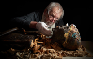 An archeologist handles a replica of King Tutankhamun's mummy