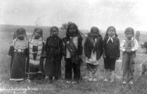 A group of Native children photographed before starting Indian Boarding School