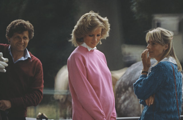 A pregnant Princess Diana in a pink sweater, two people on either side of her