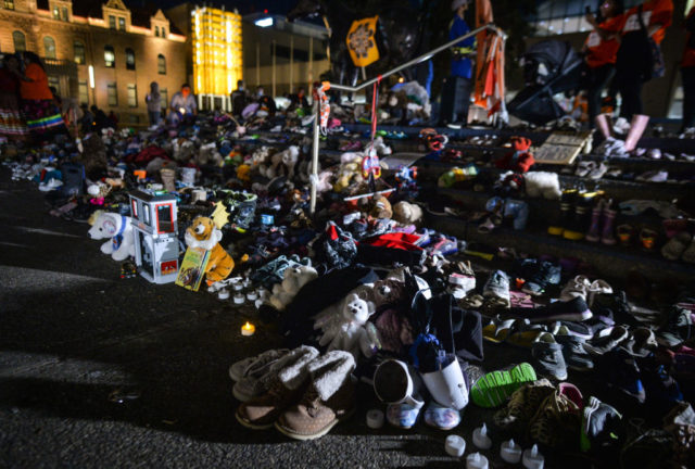 A memorial of shoes and toys marks the overwhelming number of unmarked graves found at former boarding schools