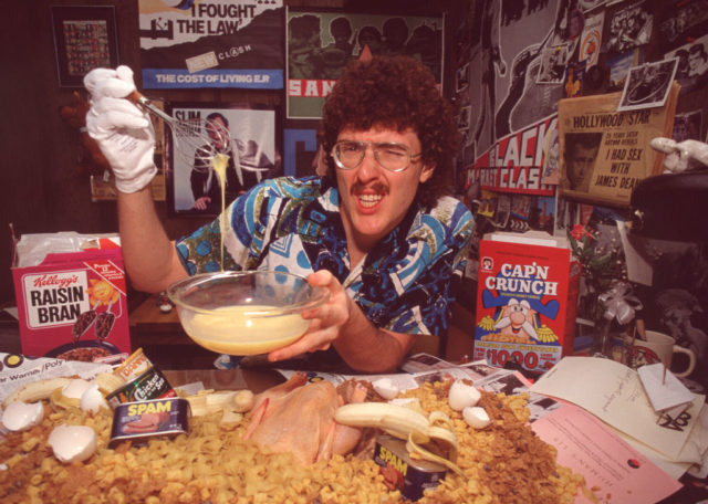 Weird Al in a Hawaiian shirt, posing with various different foods.