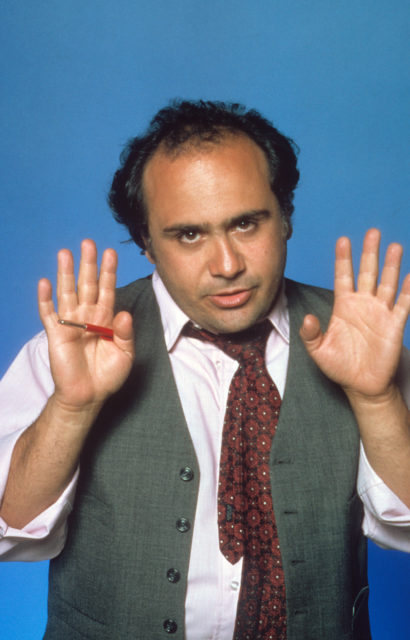 Headshot of Danny DeVito with his hands up