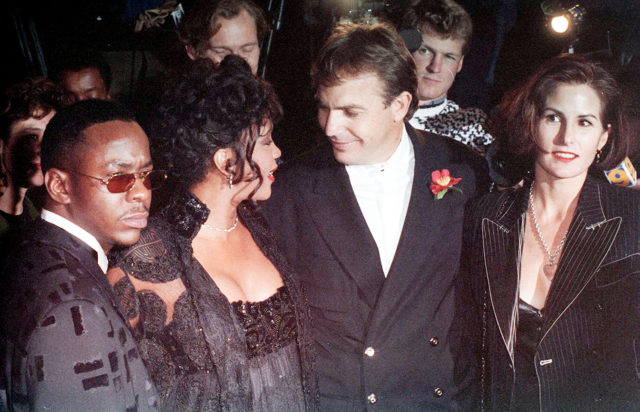 Kevin Costner smiles at Whitney Houston while arriving for an awards ceremony