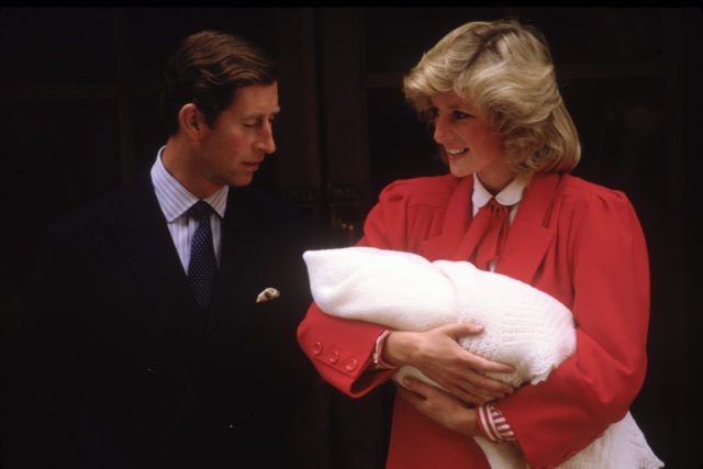 Princess Diana holding a swaddled baby, Prince Charles beside her