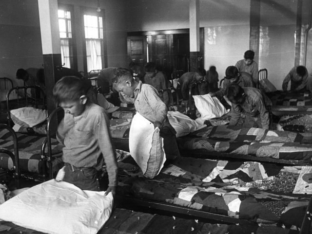 Boys make their beds while at boarding school