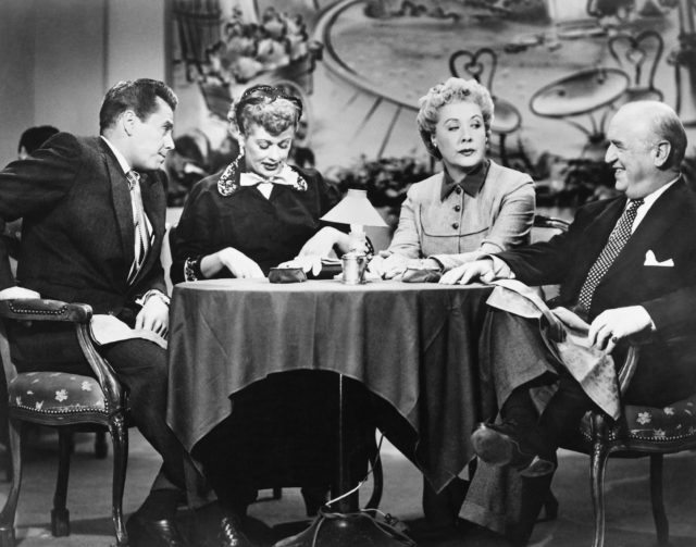 The cast of I Love Lucy sitting at a table