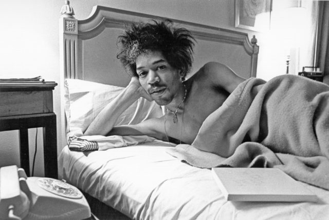 Jimi Hendrix shirtless laying in bed