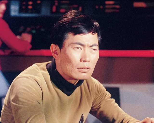 George Takei as Hikaru Sulu on 'Star Trek' scowling off in the distance while wearing a yellow shirt.