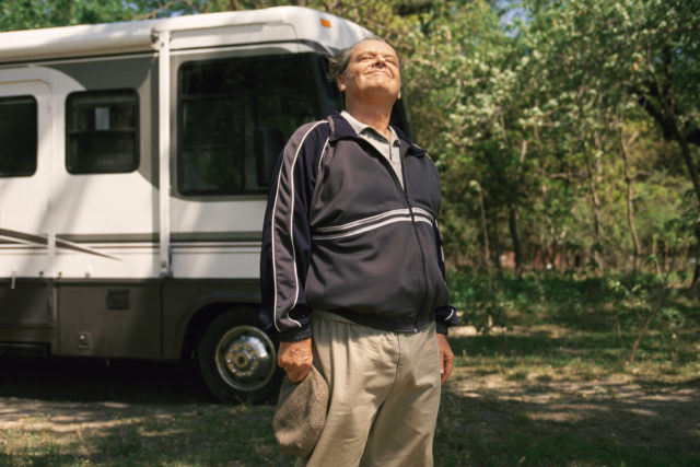 Jack Nicholson as Warren R. Schmidt in 'About Schmidt' standing in front of an RV looking up at the sky.